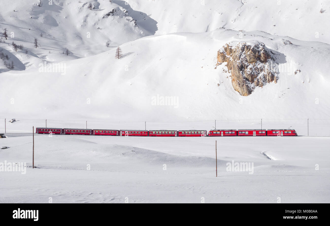 Famoso Bernina trenino rosso a piedi attraverso la neve paesaggio tra Italia e Svizzera. Foto Stock