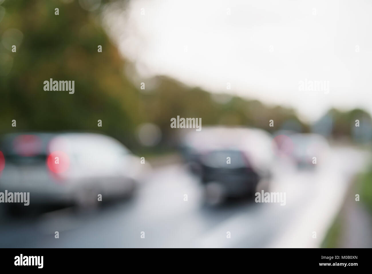 Bokeh di sfocatura di vetture in movimento su Europa via della città dopo la pioggia Foto Stock