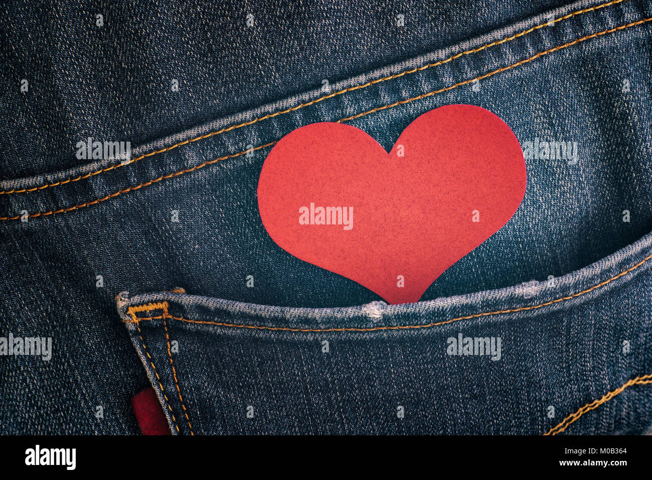 Carta rossa cuore nella tasca dei jeans. Close up Foto stock - Alamy