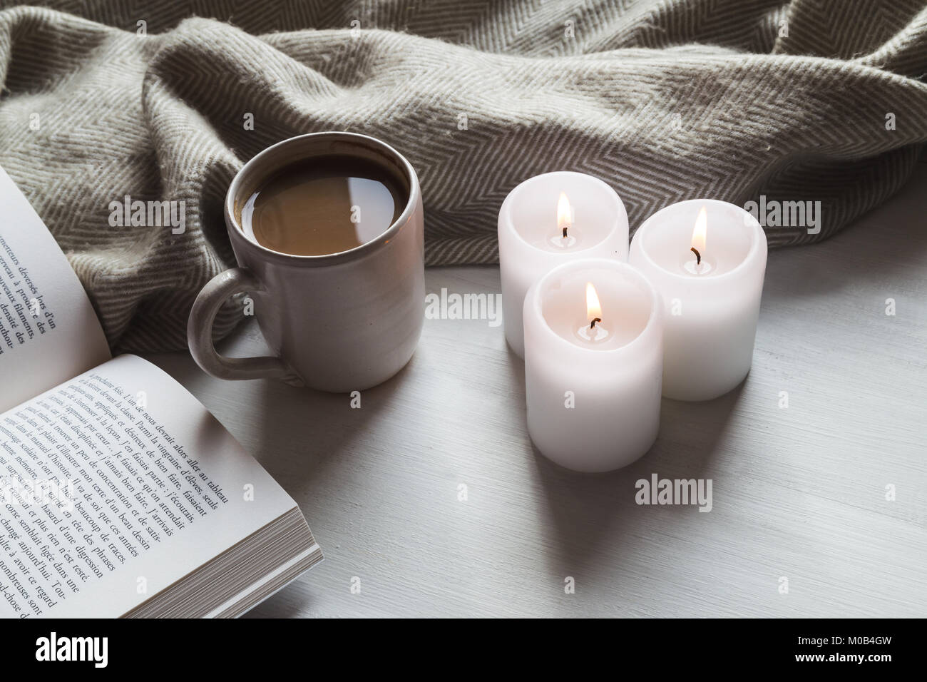Accogliente cioccolata calda e prenota con candele e coperta Foto Stock