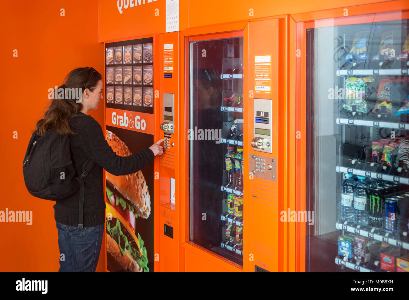 Donna che utilizza un distributore automatico in 24 ora Grab & Go cafe concetto. Foto Stock