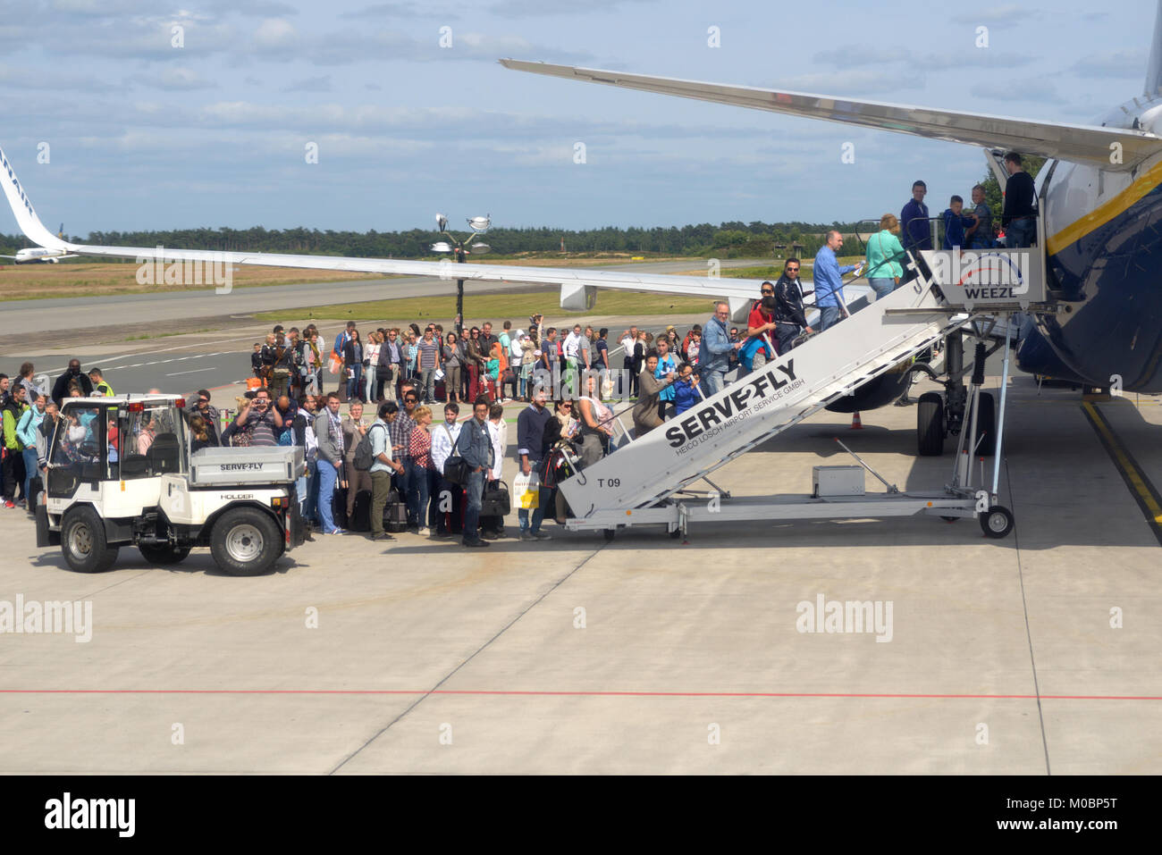 Weeze, Germania - 29 Giugno 2013: persone in attesa nella coda durante l'imbarco per l'aereo Ryanair in Weeze aeroporto, Germania il 29 giugno 2013. Ryanair w Foto Stock
