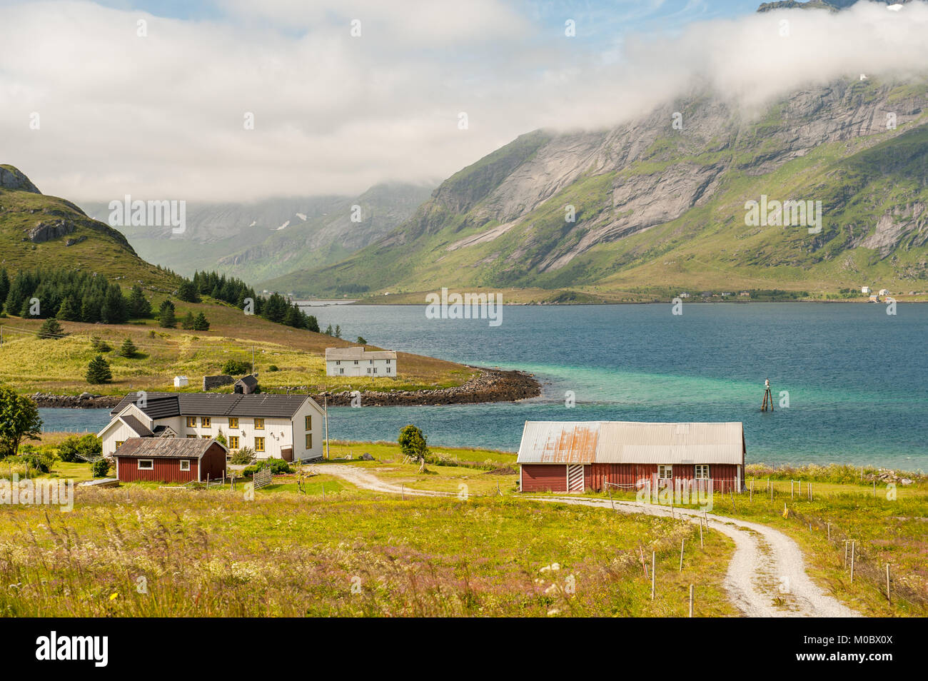 Fattoria di tradizionali edifici nel paesaggio della costa sulle isole Lofoten in Norvegia del nord. Lofoten è una popolare destinazione turistica. Foto Stock