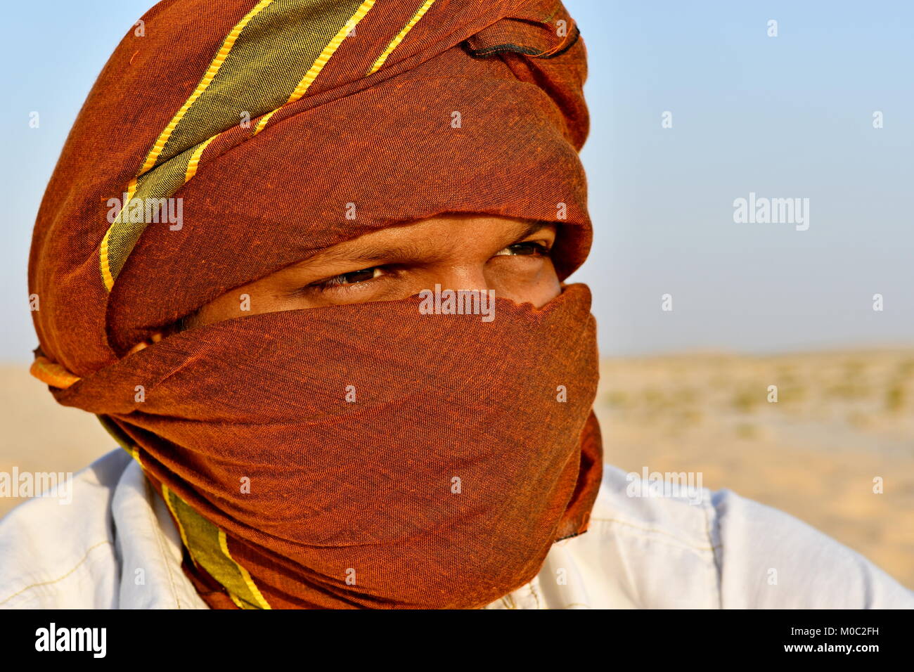 Arabo gli uomini con testa sciarpe nel deserto la luce del sole e sabbia Foto Stock