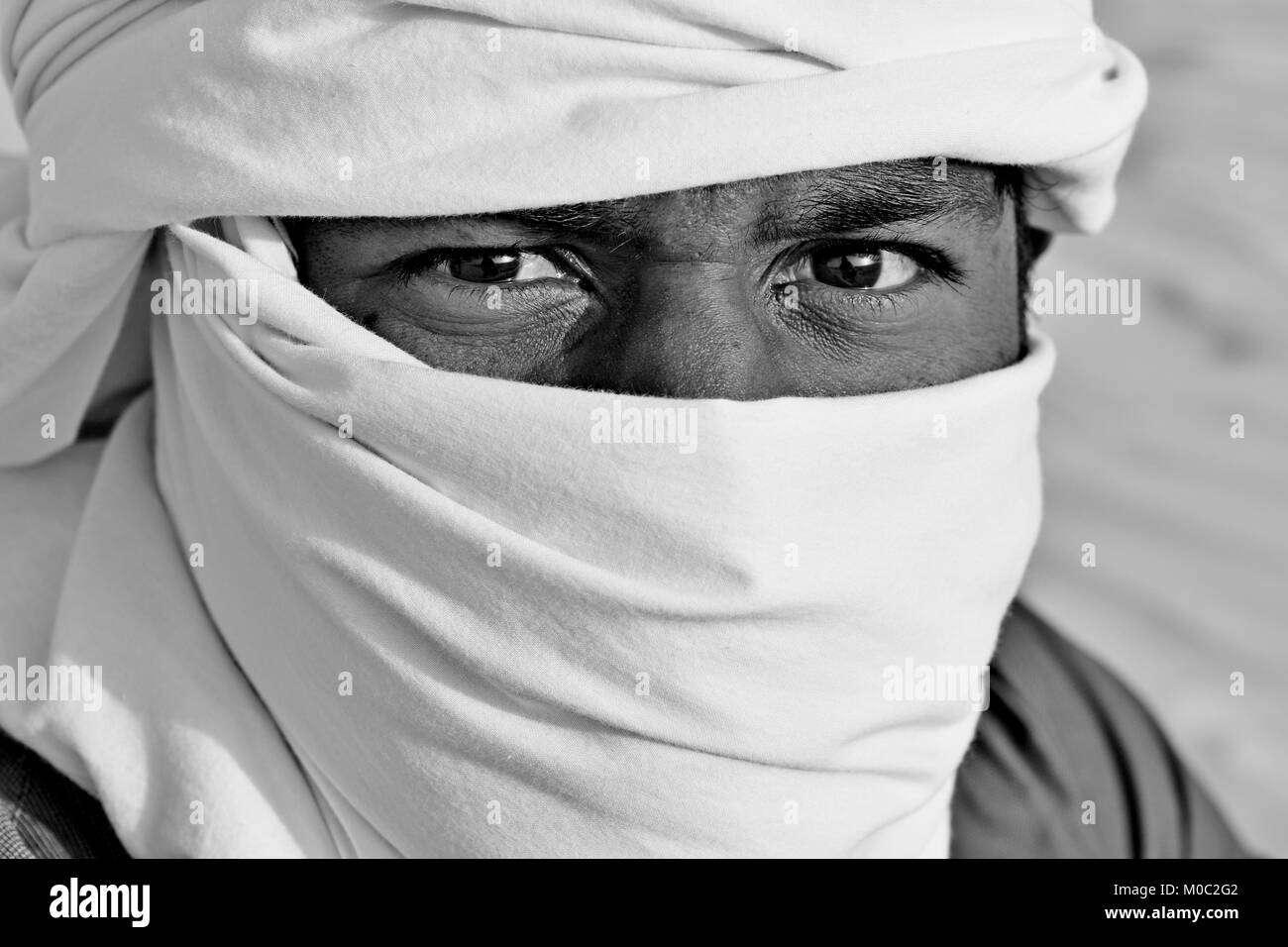 Arabo gli uomini con testa sciarpe nel deserto la luce del sole e sabbia Foto Stock