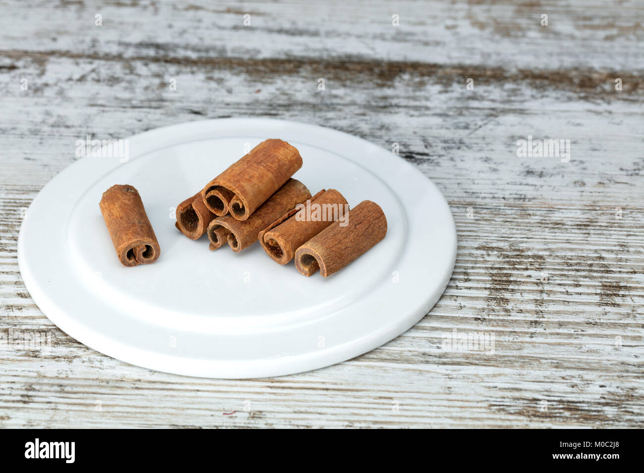 Cassia bastoncini di cannella su un vecchio bianco tavola di legno. Foto Stock
