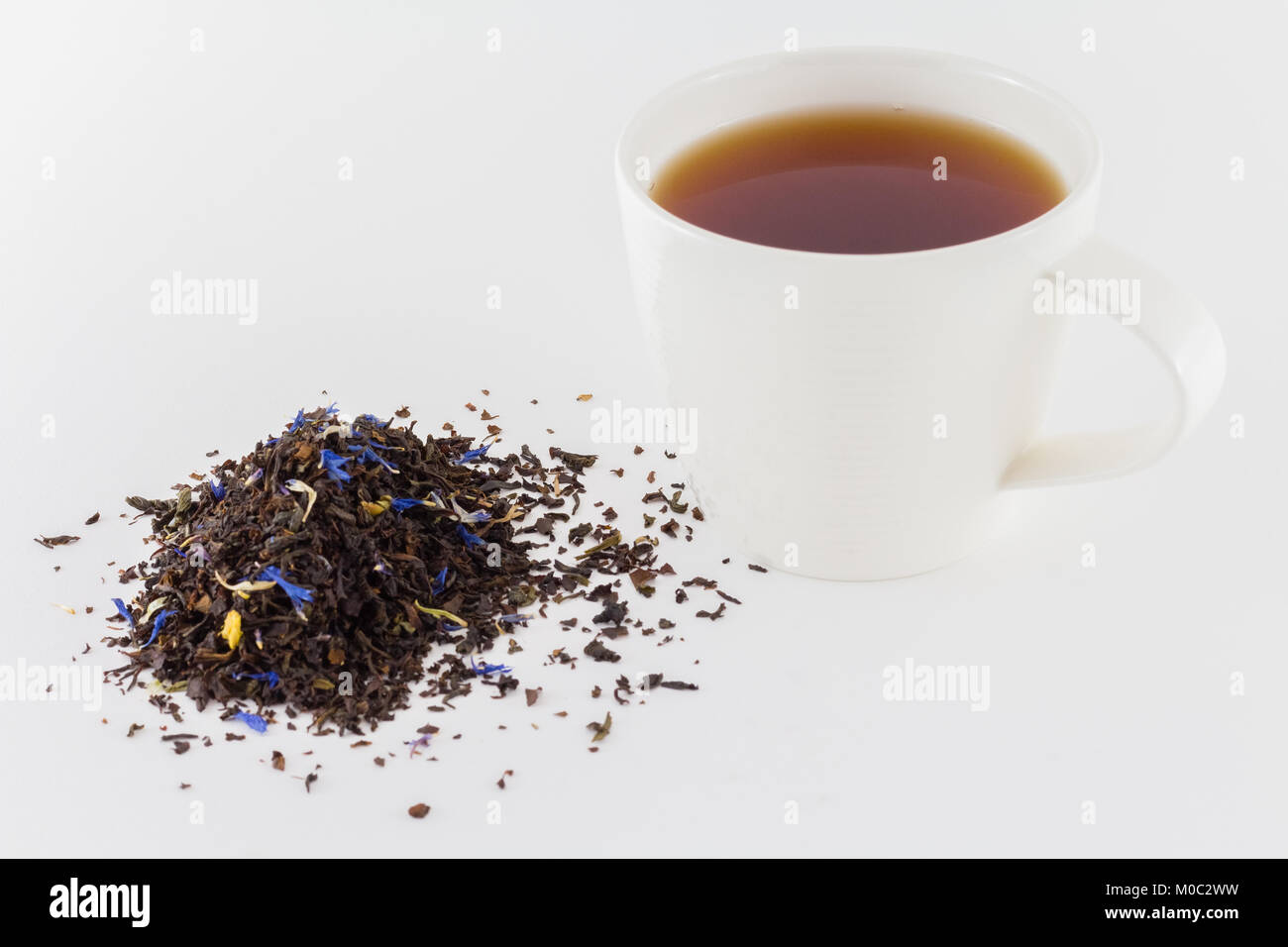 Tazza di tè con fresche biologiche le foglie di tè isolati su sfondo bianco Foto Stock