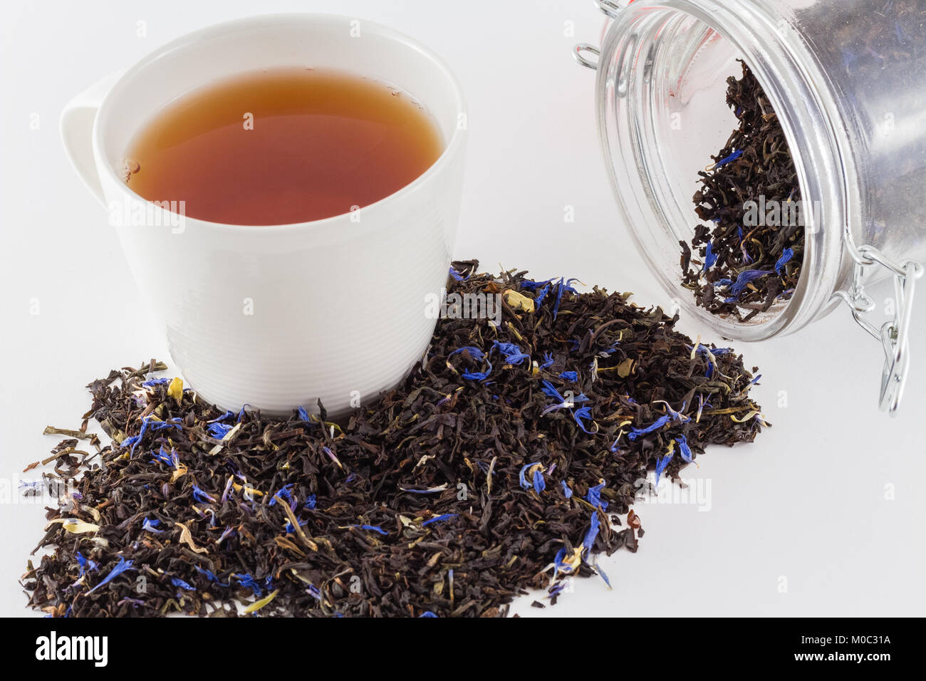 Tazza di tè con un fresco e le foglie di tè e tè vaso con le foglie di tè isolati su sfondo bianco Foto Stock