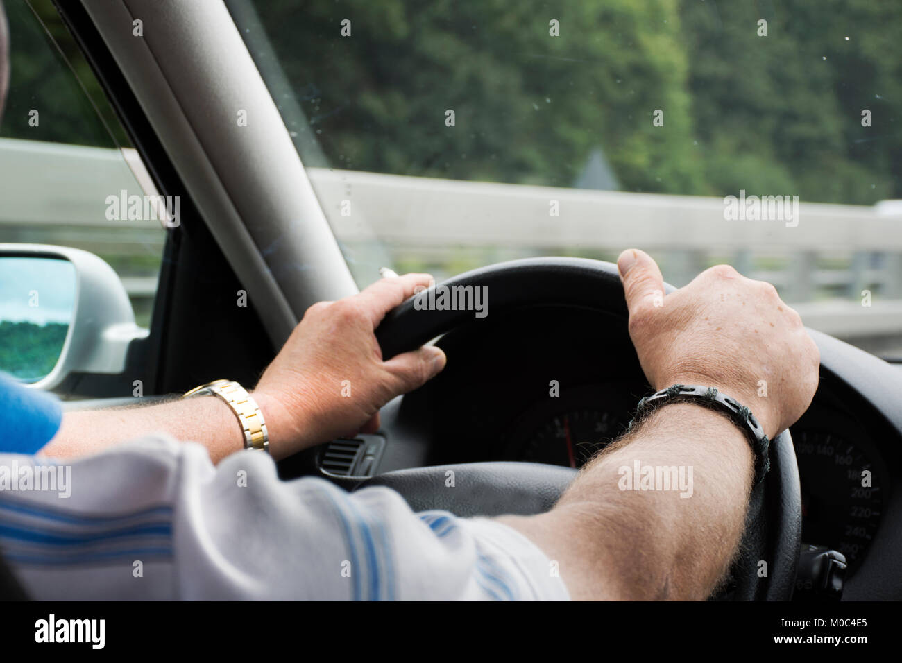 Il tedesco vecchio uomo alla guida di auto molto veloce e di fumare sigaretta sulla autostrada di Stoccarda andare in Austria e in Italia il 1 settembre 2017 a Stoccarda, Germania Foto Stock