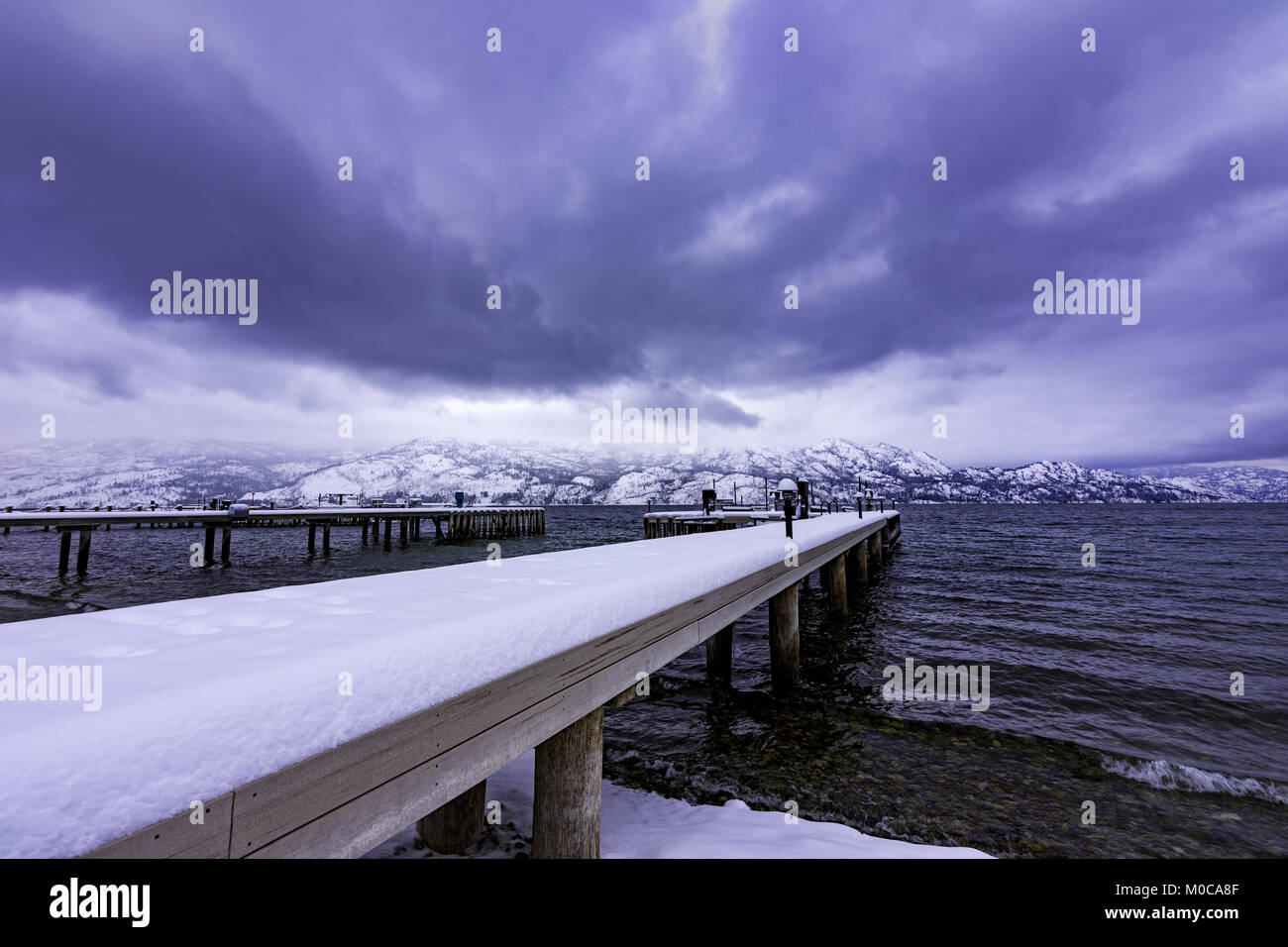 Coperta di neve dock sul Lago Okanagan West Kelowna British Columbia Canada su un giorno di tempesta Foto Stock