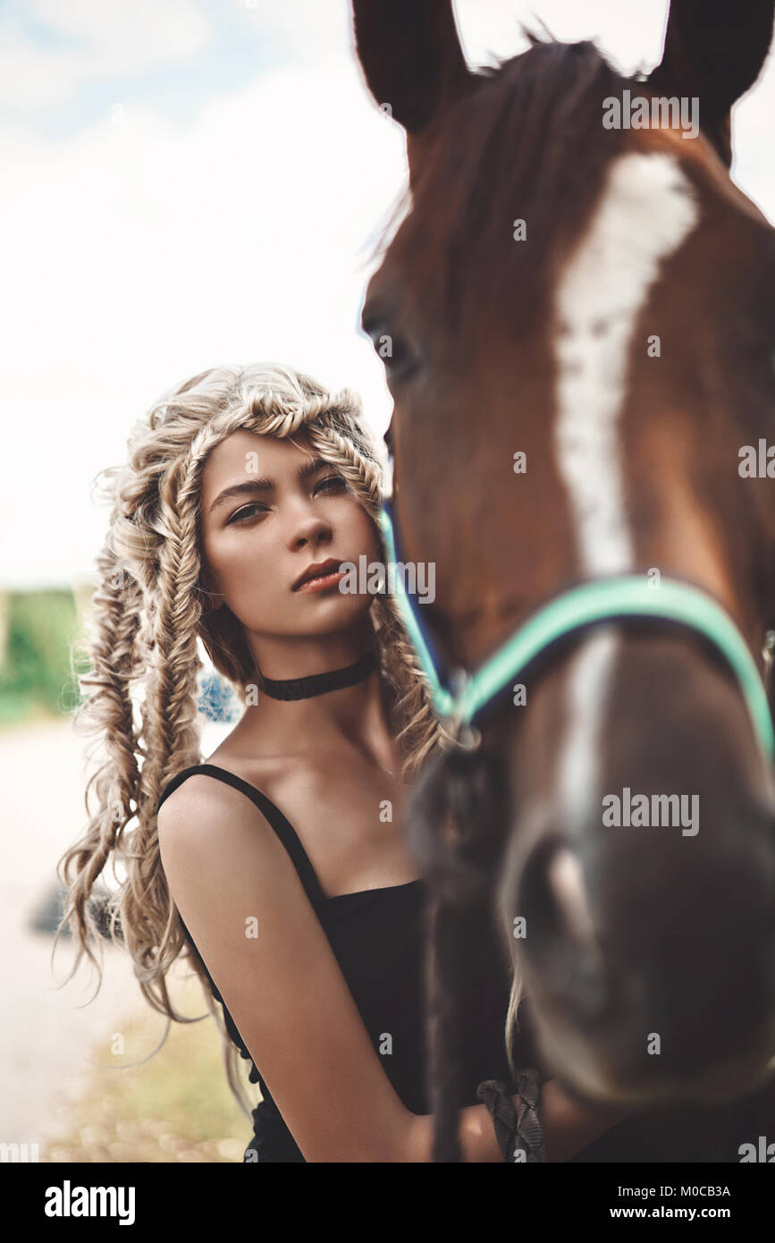 Outdoor fashion Ritratto di giovane e bella ragazza con cavallo marrone. Stile hippie. Estate vibes. La stagione autunnale Foto Stock