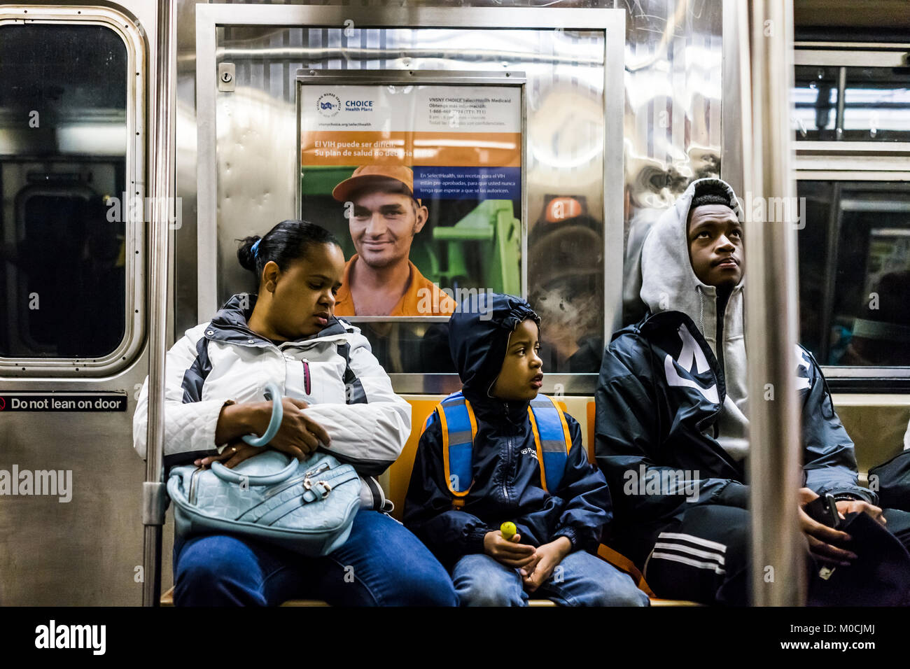 La città di New York, Stati Uniti d'America - 28 Ottobre 2017: Famiglia persone con bambini seduti su sedie in metropolitana treno auto cercando in transito nella mattina di NYC Foto Stock