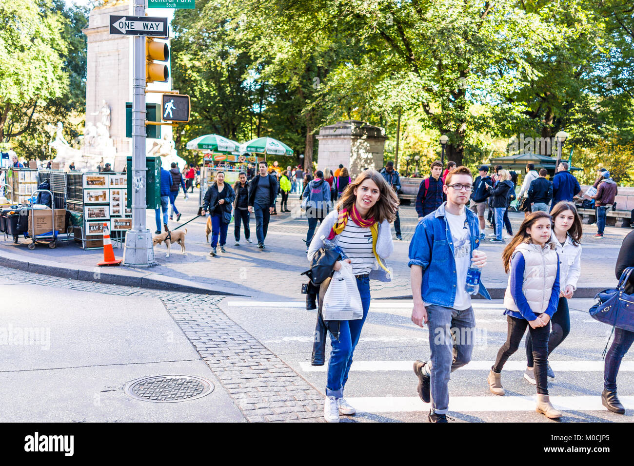 La città di New York, Stati Uniti d'America - 28 Ottobre 2017: Midtown Manhattan con felice giovani attraversando via del Columbus Circle dal Central Park road nel traffico Foto Stock