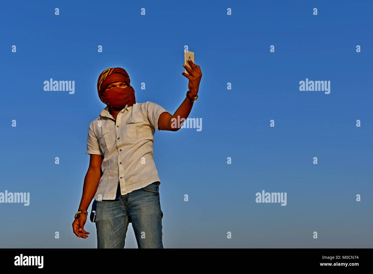 Gli uomini nel deserto di sabbia giocando ed appendere fuori con i telefoni cellulari e rendendo selfies Foto Stock