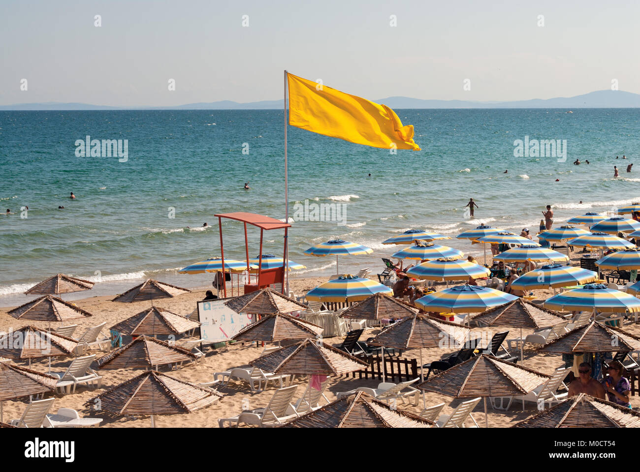 Bandiera gialla al mare spiaggia indica pericolo di nuoto. Città di Nessebar, Bulgaria Foto Stock