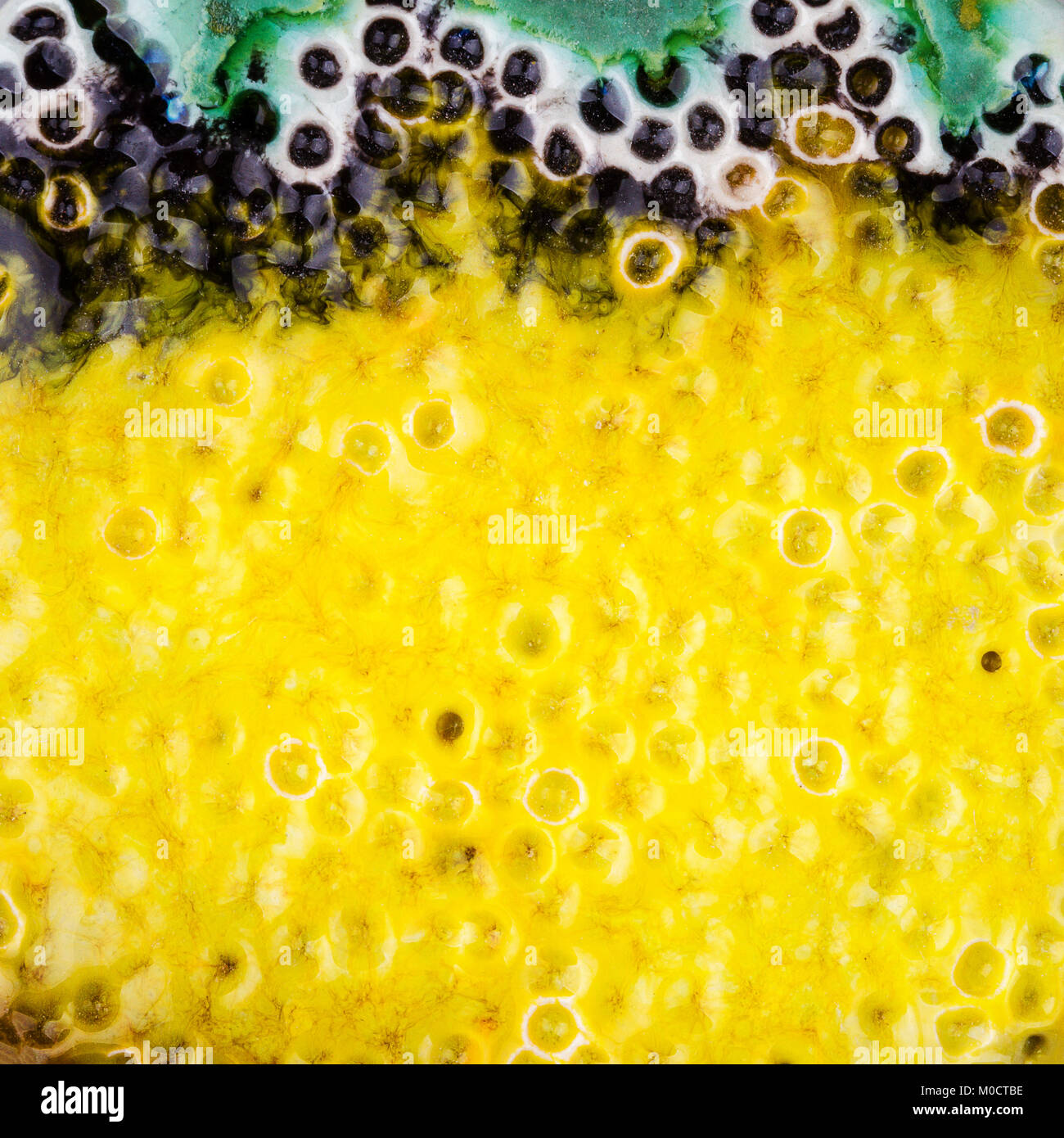 Closeup colpo di vetrate giallo punteggiato verde e nero texture ceramica Foto Stock