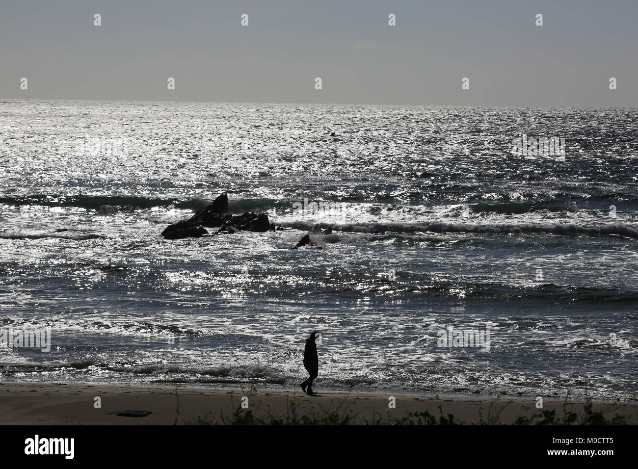 Uomo a camminare sulla spiaggia spiaggia lungo la selvaggia modo atlantico, Irlanda Foto Stock