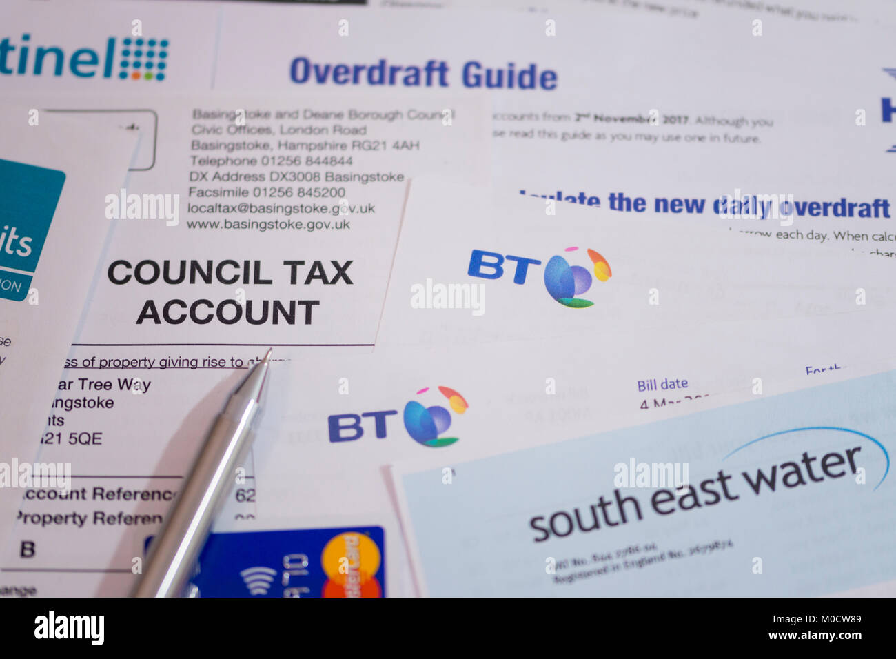 Una selezione di fatture, una carta di credito e una guida alle bozze. Concetto - costo della vita, aumento dell'inflazione, recessione, debito delle famiglie Foto Stock