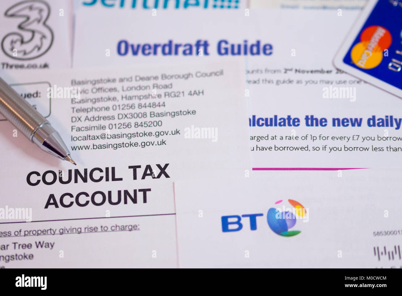 Una selezione di fatture, una carta di credito e una guida alle bozze. Concetto: Debito, finanza personale, problemi di denaro, tassa di consiglio, fatture Foto Stock