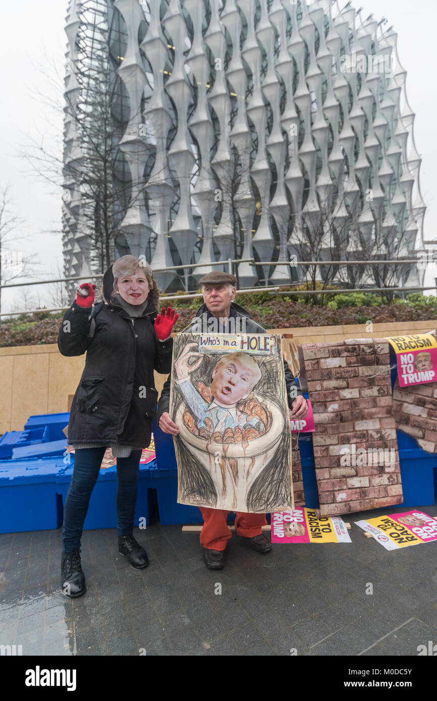 Londra, Regno Unito. Xx gen, 2018. Londra, Regno Unito. Il 20 gennaio 2018. Stand Up al razzismo tenere la prima protesta al di fuori della nuova ambasciata degli Stati Uniti a Nine Elms, contro il Presidente Trump chiaro il razzismo nel descrivere le nazioni africane, Haiti e El Salvador come 'shitholes', che ha causato l'offesa e indignazione in tutto il mondo. Un manifestante tiene il suo naso al di sopra di una immagine grafica di Trump con la dicitura "Chi è in un "foro?, e un 'smililng Thweresa può' è al suo fianco. Credito: ZUMA Press, Inc./Alamy Live News Foto Stock