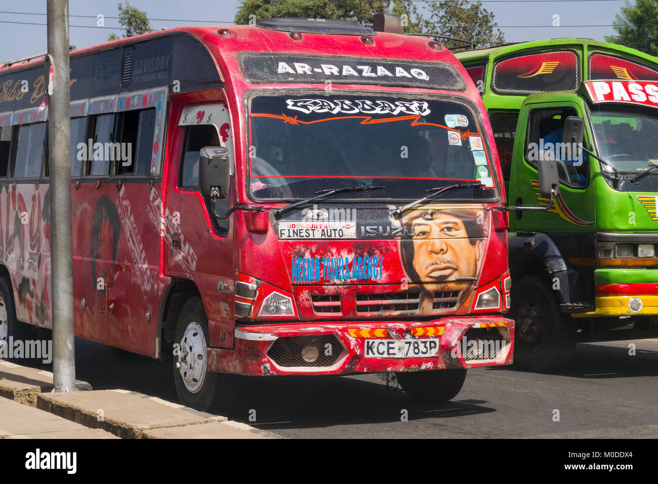 Un bus rosso con un dipinto di Muammar Gheddafi sulla parte anteriore attende nel traffico, Nairobi, Kenya, Africa orientale Foto Stock