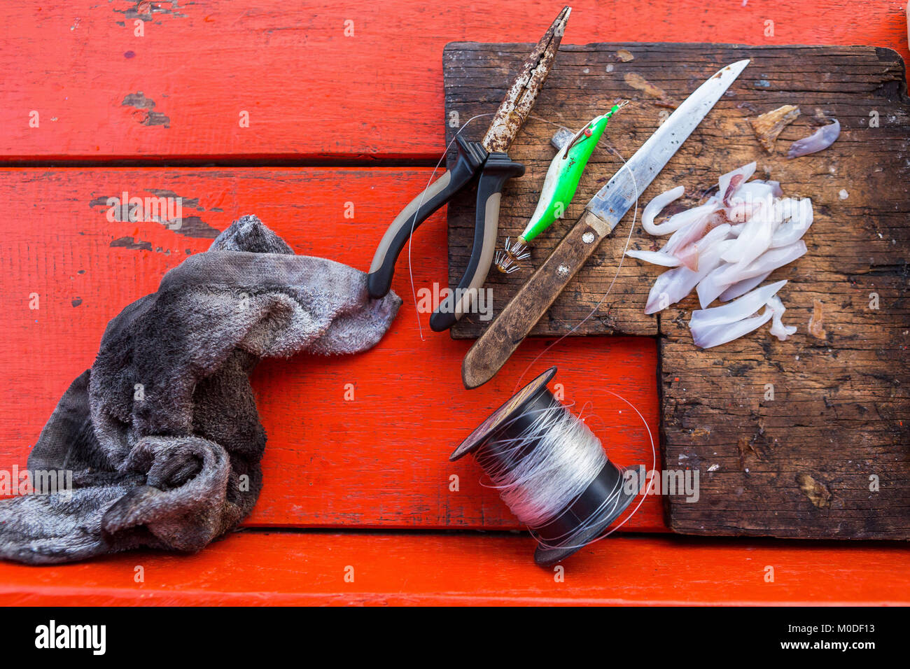 Attrezzi da pesca con vittima di calamari e tagliere Foto Stock