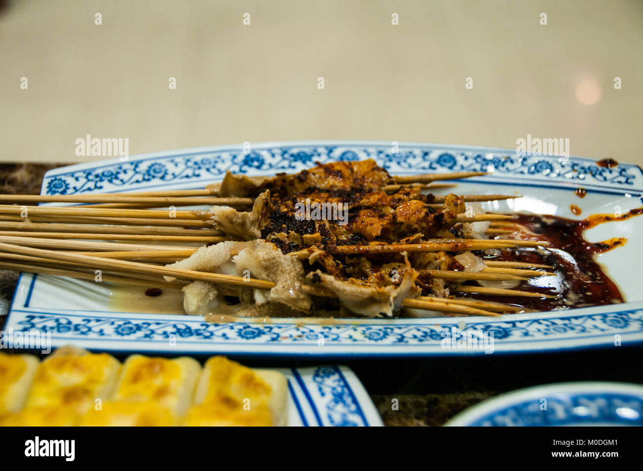 Un piatto di kebab realizzato da frattaglie (stomaco) soffocato in un olio aromatizzato al peperoncino Salsa. Sfocato in primo piano di una piastra di pentola di adesivi. In un ristorante del Foto Stock
