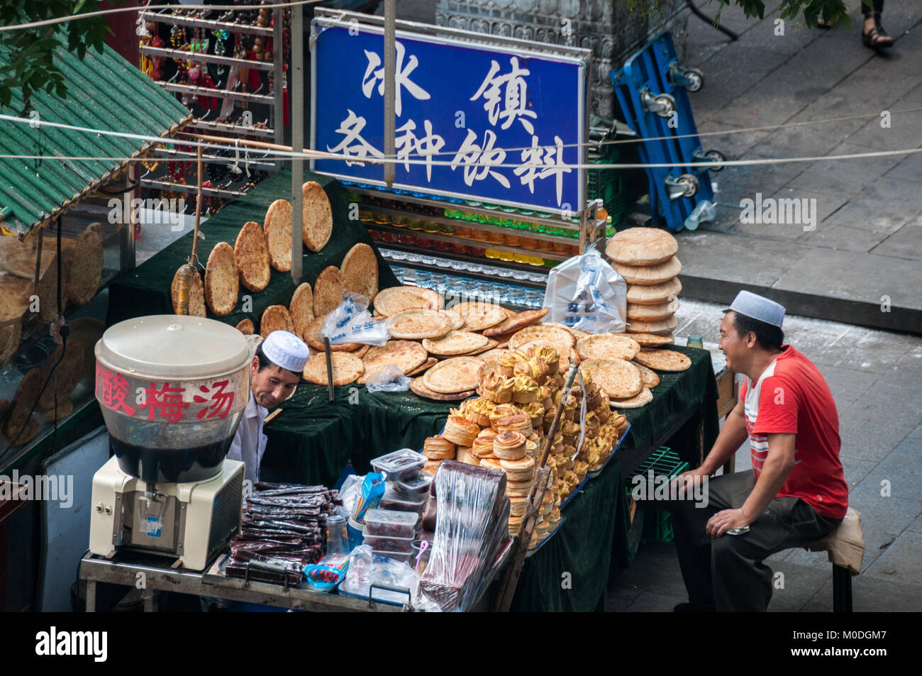 Due venditori musulmano su Beiyuanmen Street nel Quartiere Musulmano, Xi'an, Shaanxi Province, Cina. Uno è la vendita di pane musulmana mentre l'altra è la vendita Foto Stock