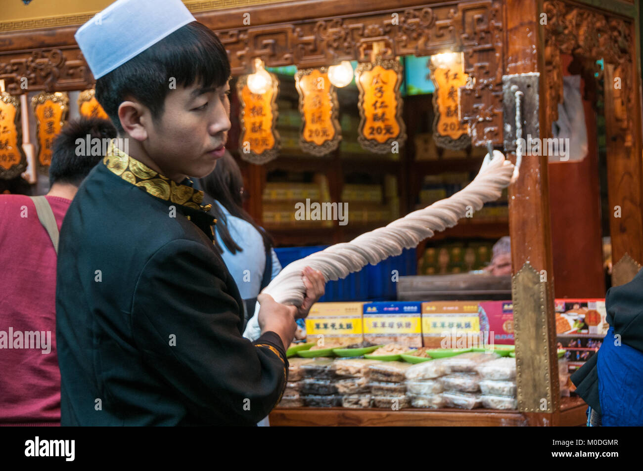 Rendendo martellato candy sulla strada. Beiyuanmen Street nel Quartiere Musulmano, Xi'an, Shaanxi Province, Cina. Foto Stock