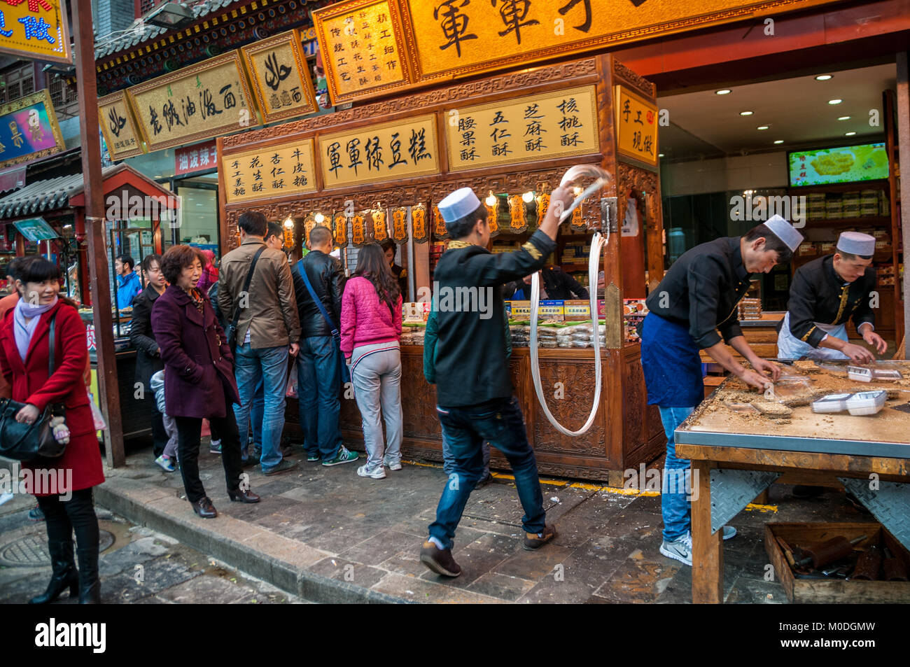 Rendendo martellato candy sulla strada. Beiyuanmen Street nel Quartiere Musulmano, Xi'an, Shaanxi Province, Cina. Foto Stock