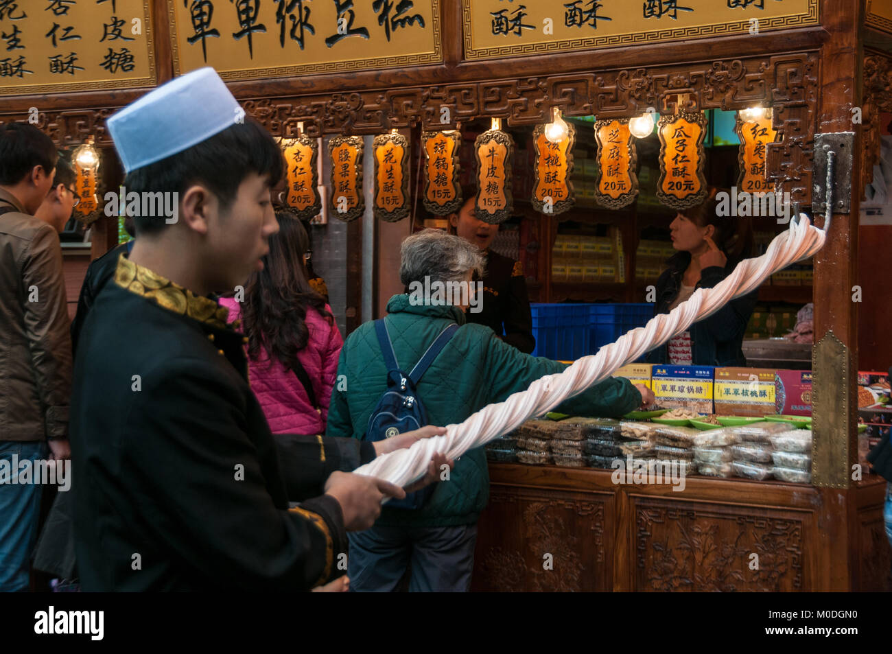 Rendendo martellato candy sulla strada. Beiyuanmen Street nel Quartiere Musulmano, Xi'an, Shaanxi Province, Cina. Foto Stock