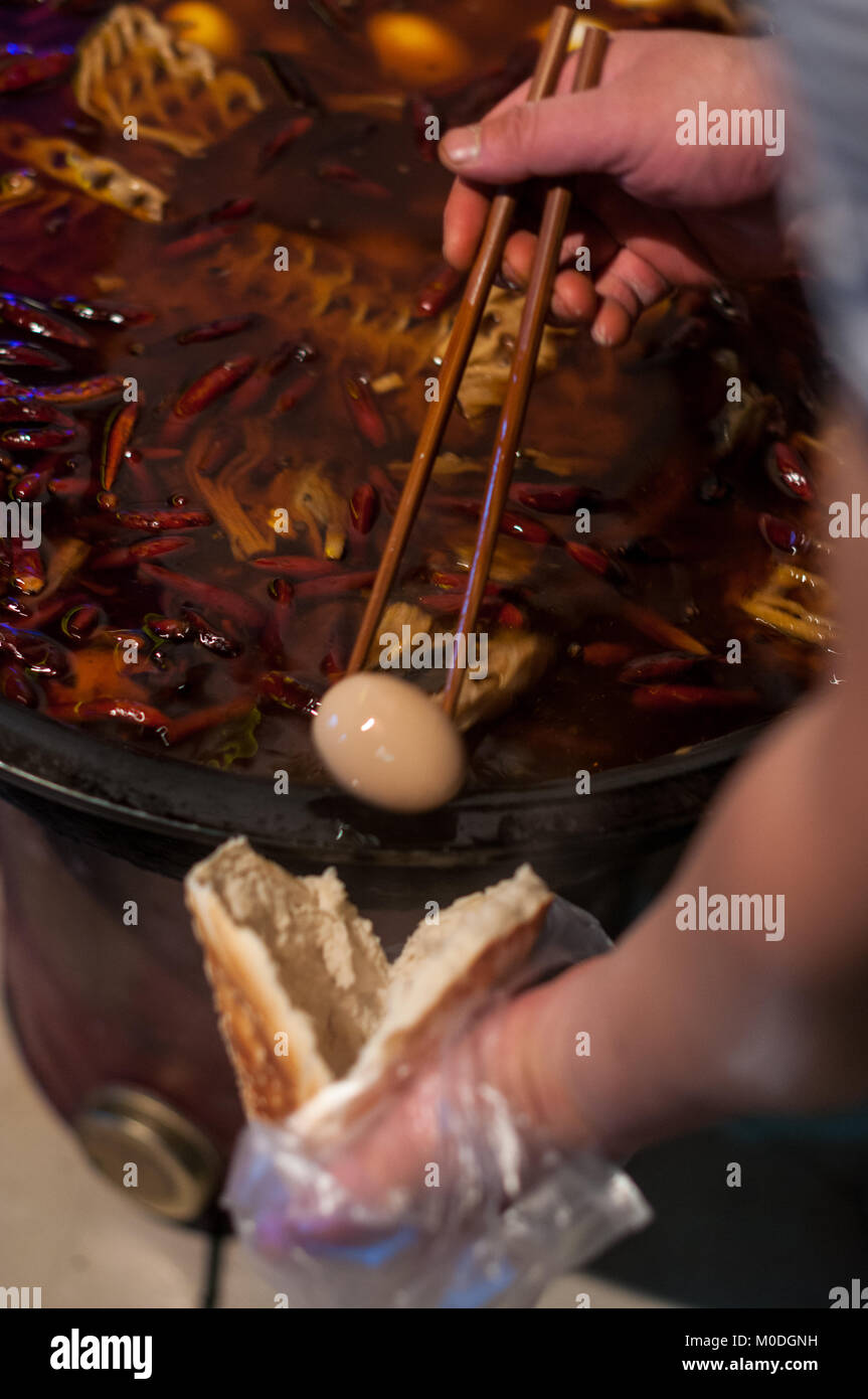 Mettere un uovo dal vecchio zuppa nella tasca di un alto forno pane nel Quartiere Musulmano, Xi'an, Shaanxi Province, Cina. Come ha visitato su una perduta Pla Foto Stock