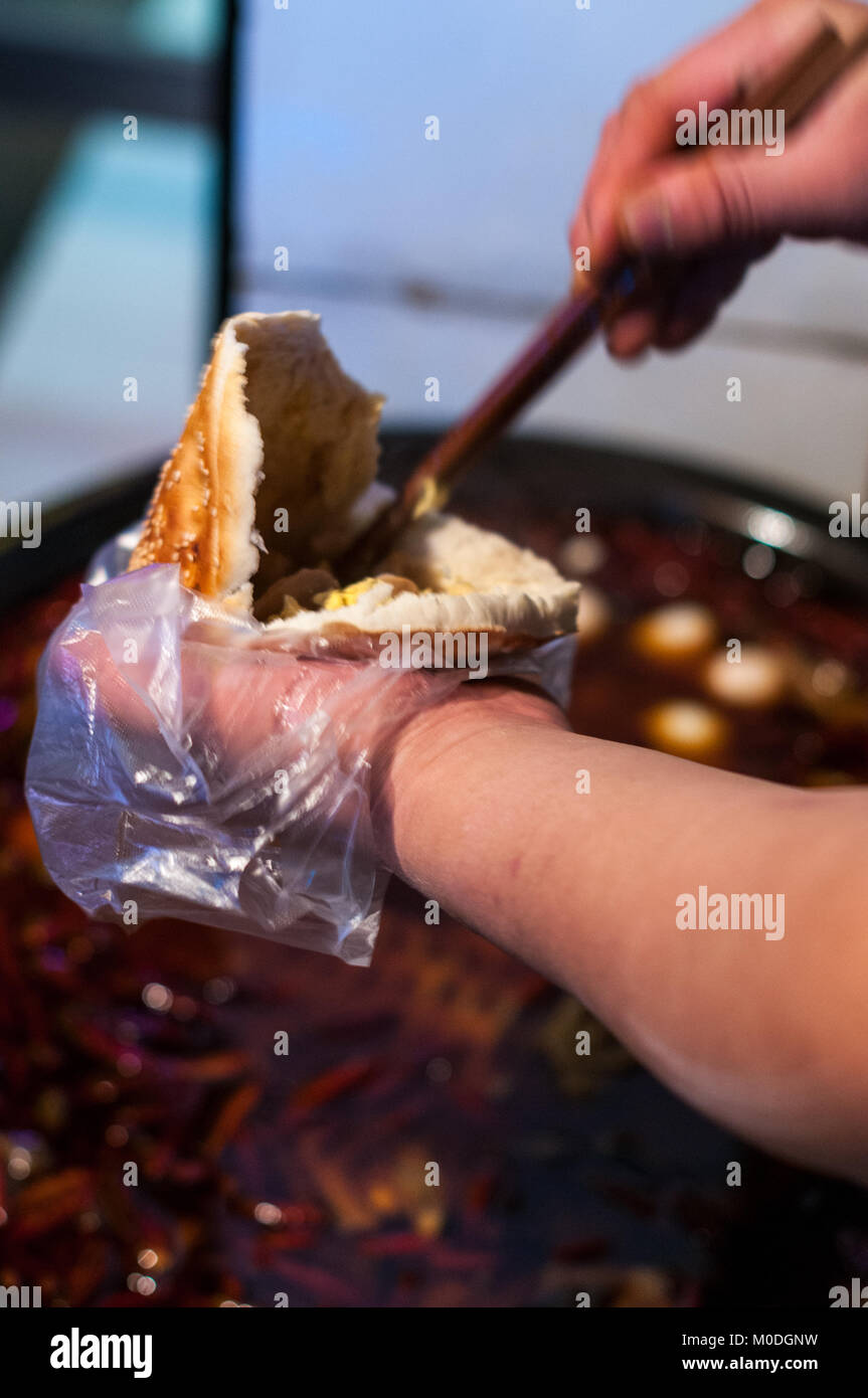 Mettere un uovo dal vecchio zuppa nella tasca di un alto forno pane nel Quartiere Musulmano, Xi'an, Shaanxi Province, Cina. Come ha visitato su una perduta Pla Foto Stock