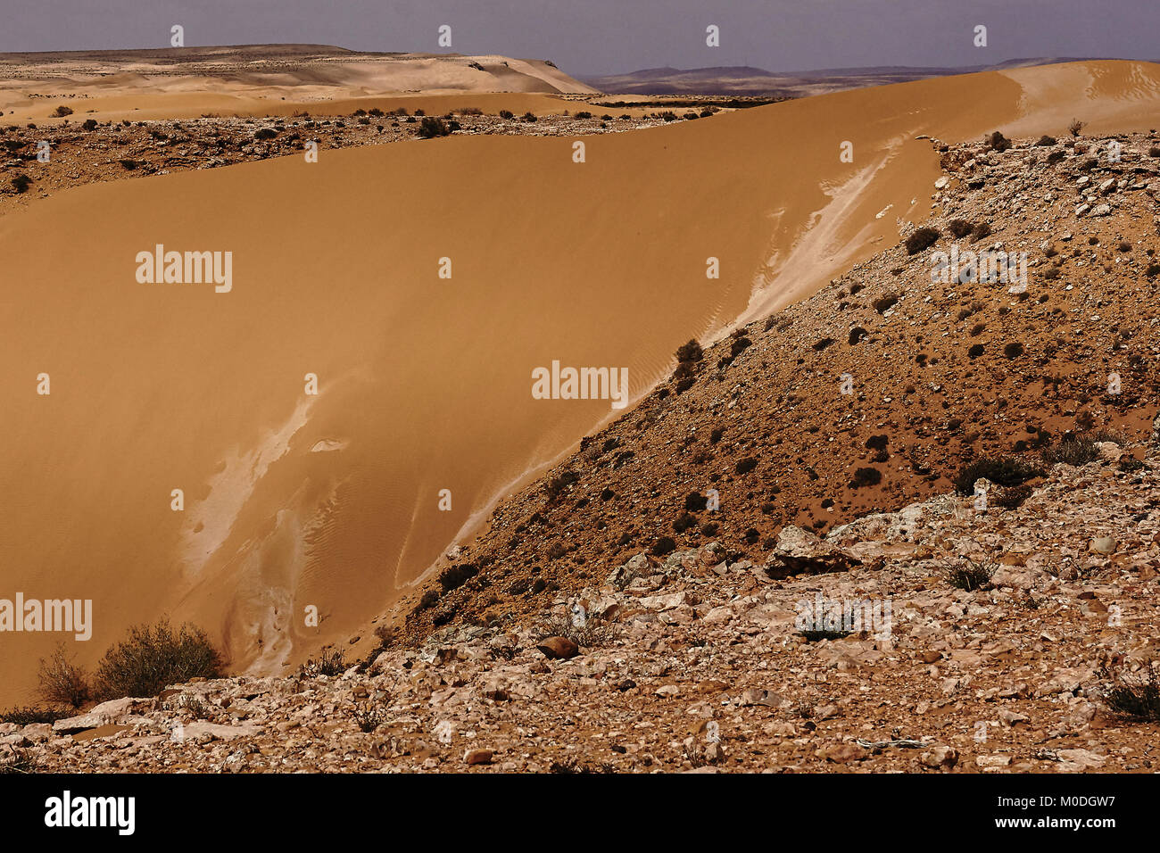 Guardando attraverso le rocce e dune di sabbia su un deserto marocchino Foto Stock
