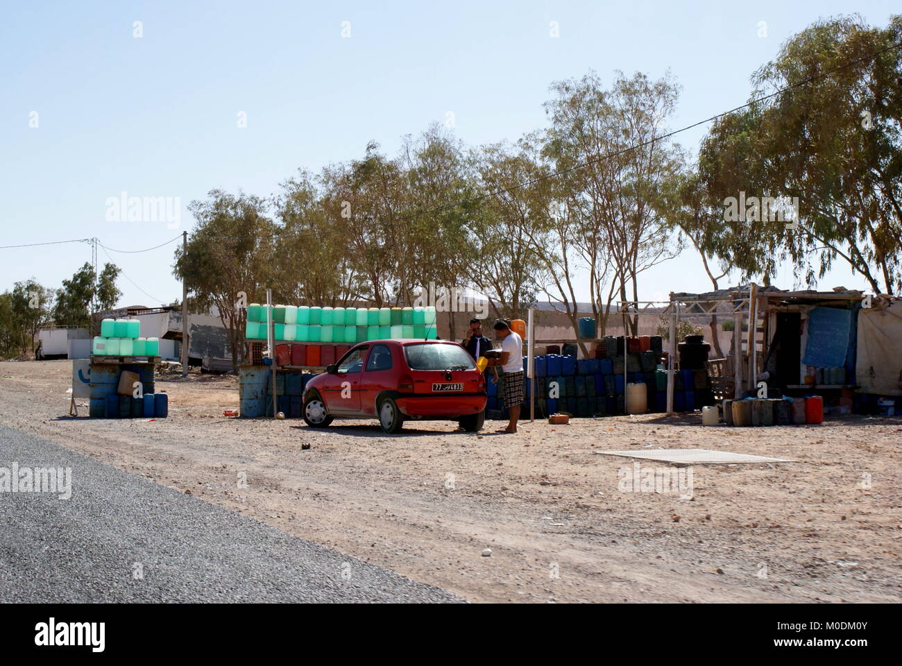 Un auto si riempie di benzina di contrabbando contrabbando da Libia sul sud tunisino strada Foto Stock