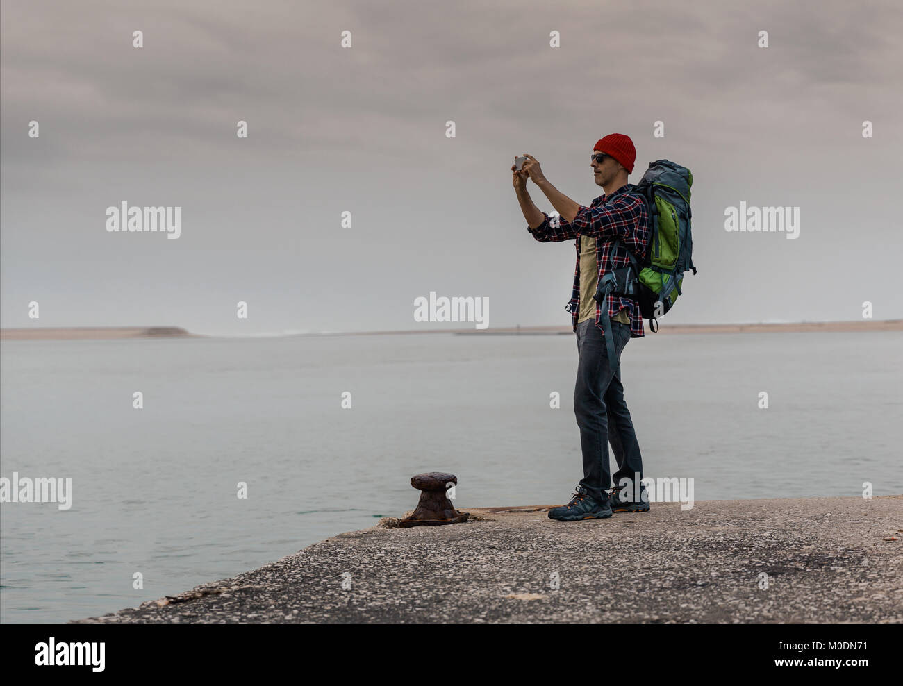 Uomo che viaggia zaino godendo della splendida vista sul lago Foto Stock