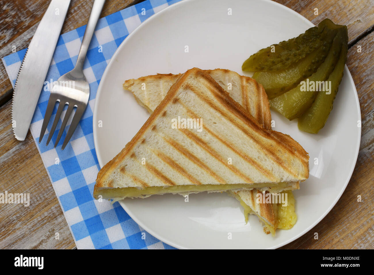 Il croccante pane tostato con il formaggio e il cetriolo sottaceto sul lato Foto Stock