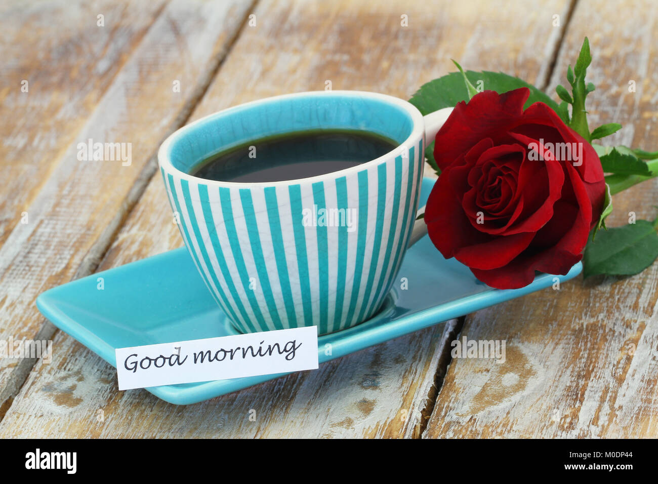 Buona mattina card con tazza di caffè e una rosa rossa sul rustico superficie in legno Foto Stock