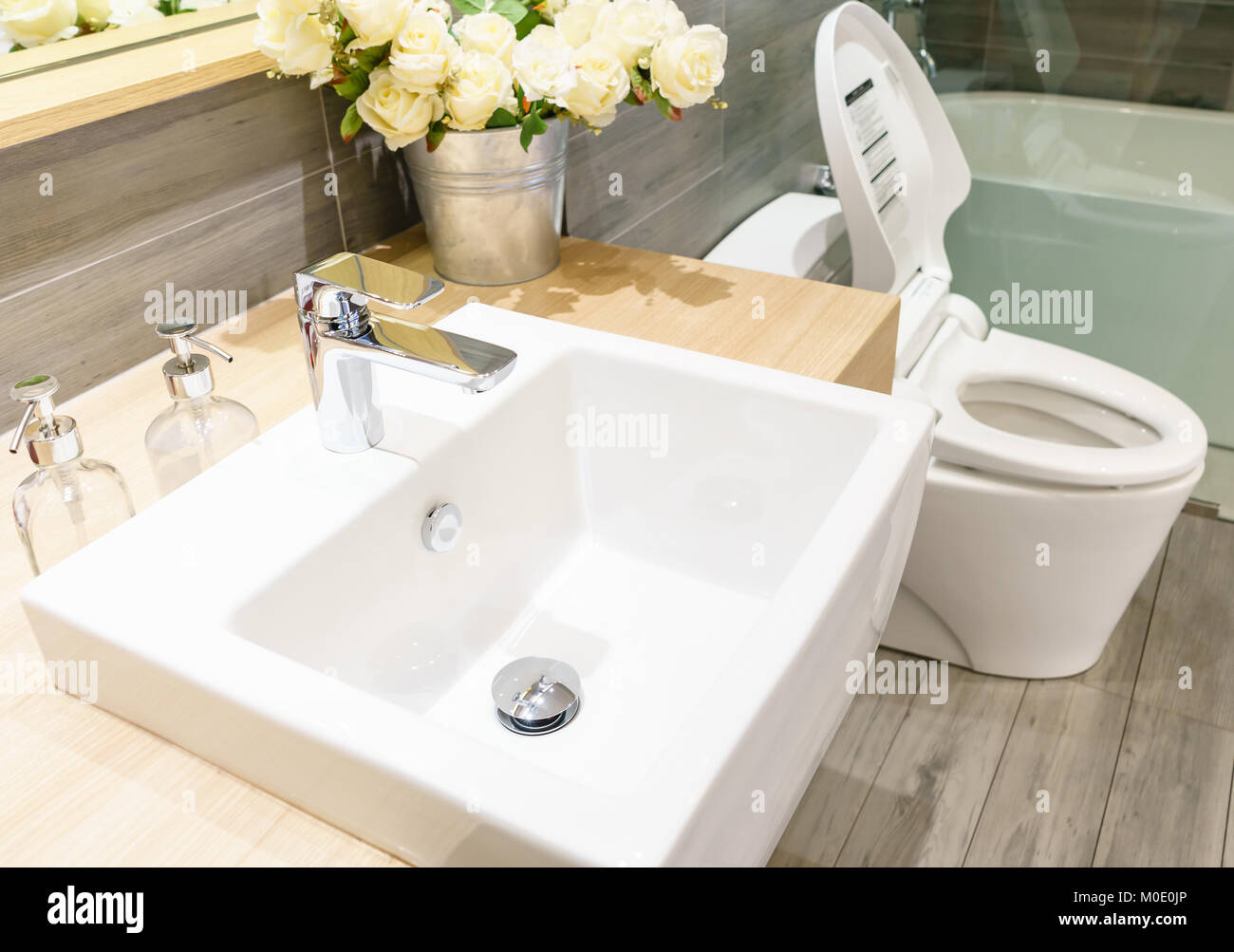 Moderna e spaziosa sala da bagno con mattonelle luminose con wc e lavandino. Vista laterale Foto Stock