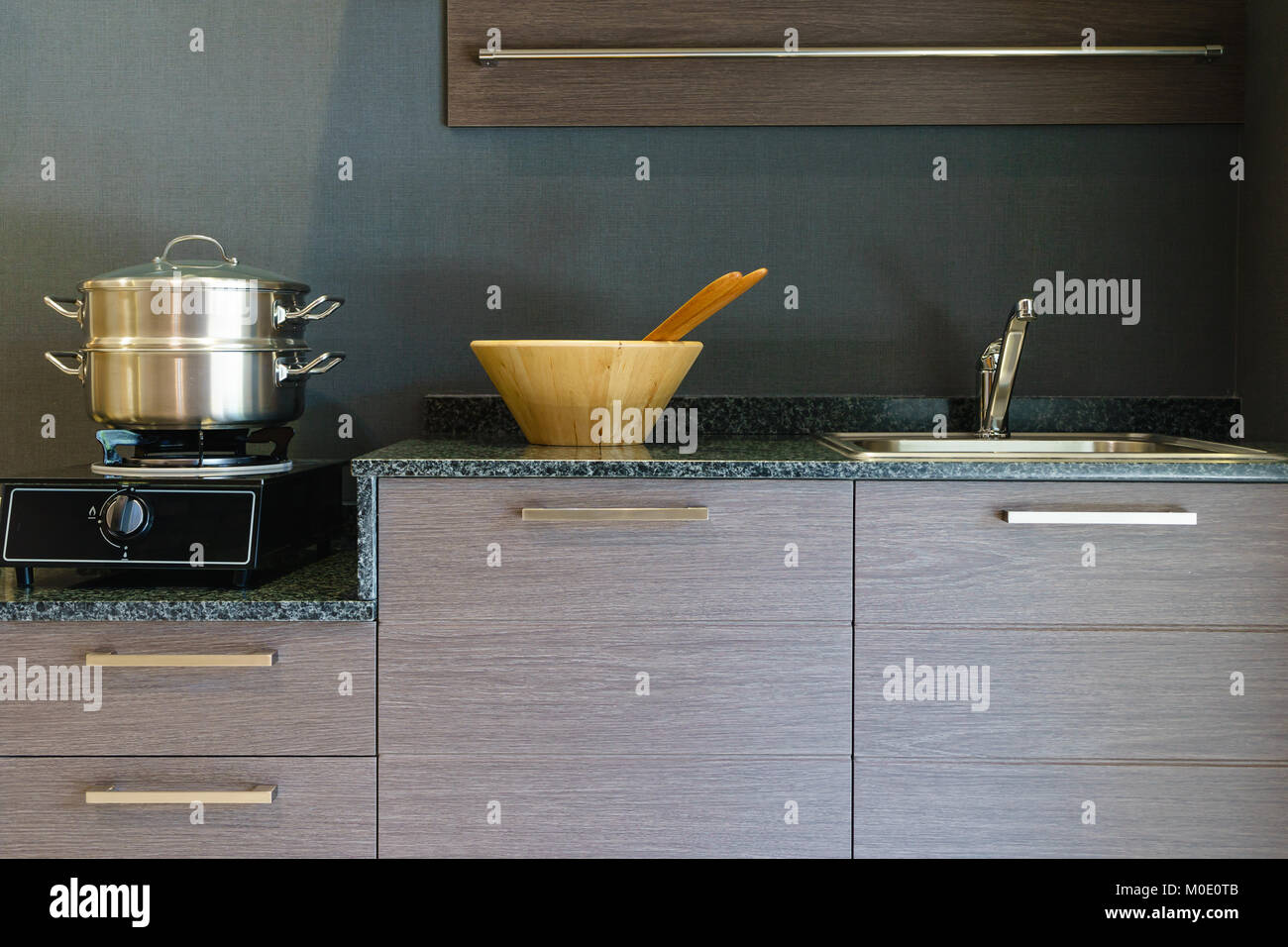 Close-up di acciaio inossidabile pentola di cottura sul piano di cottura ad induzione in contemporanea moderna cucina casalinga. Foto Stock