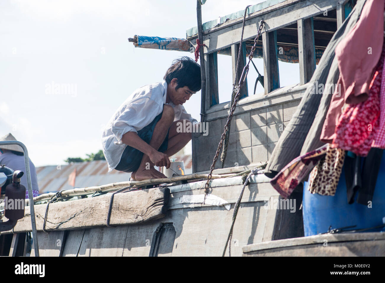 Uomo di ritirarvi in barca, delta del Mekong, Vietnam Foto Stock