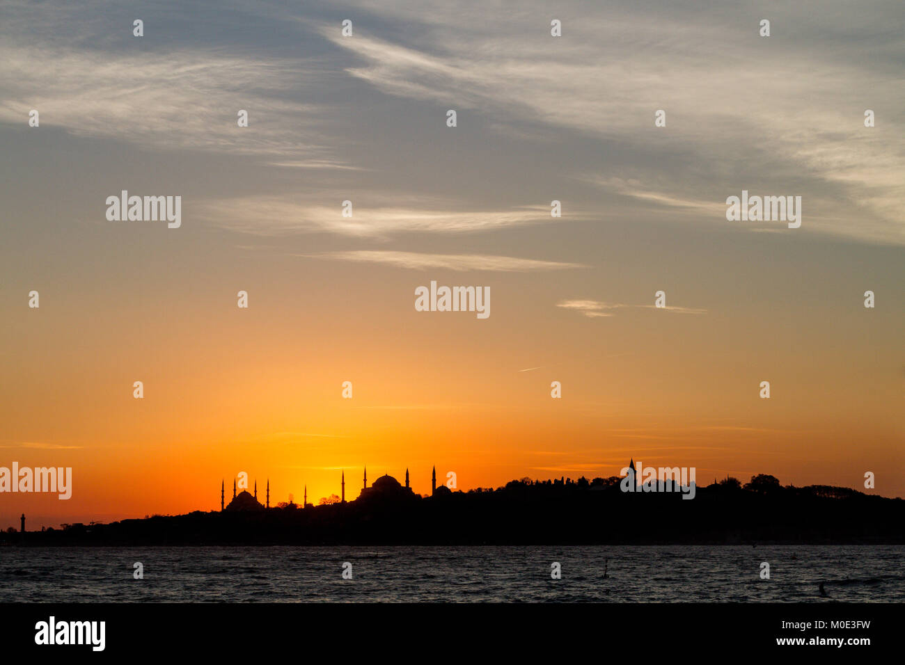 Silhouette di Istanbul con cupole e minareti della Moschea Blu e Hagia Sophia, al tramonto, dal Bosforo Foto Stock