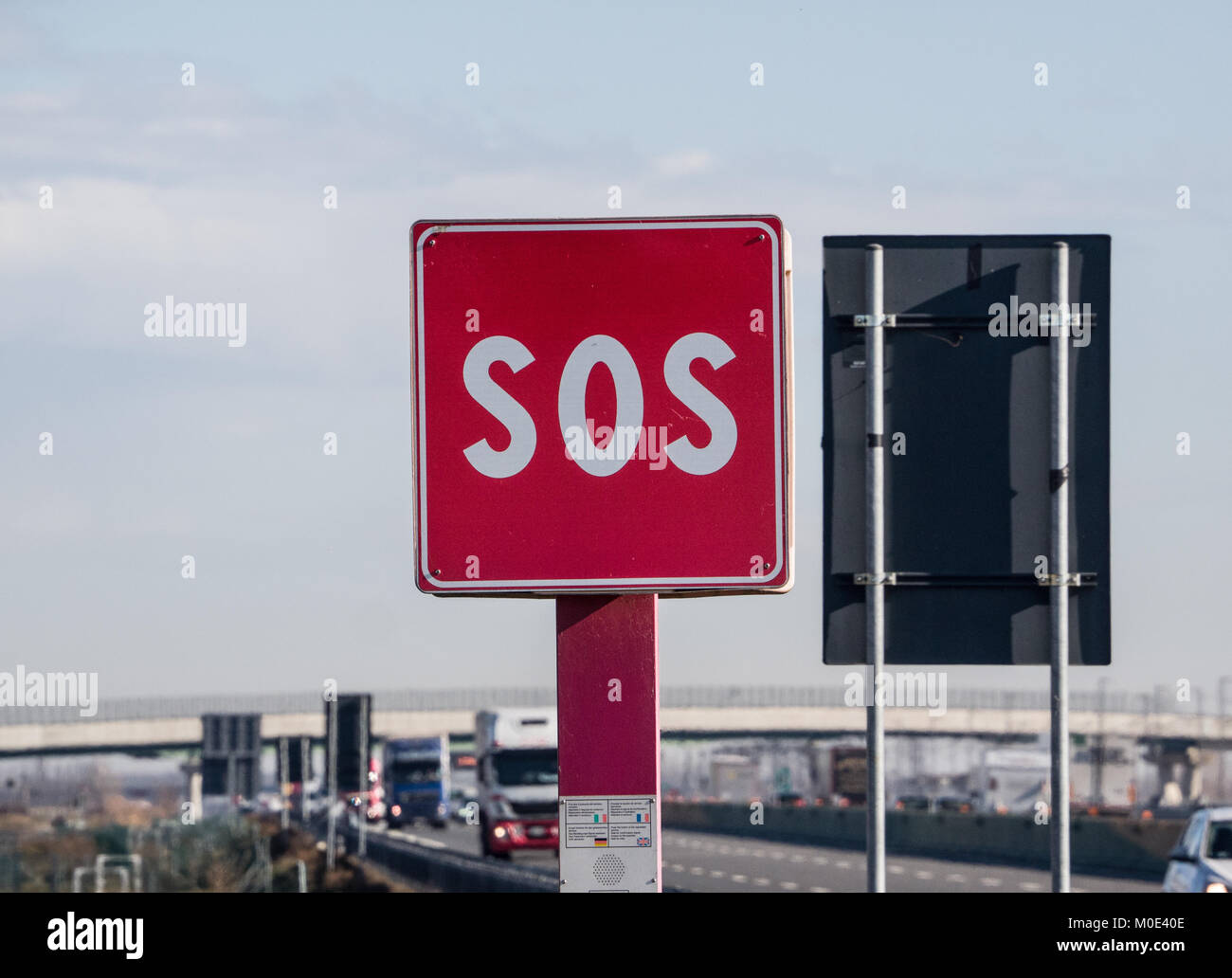 Il traffico autostradale presi da un area di emergenza con un segno di SOS Foto Stock