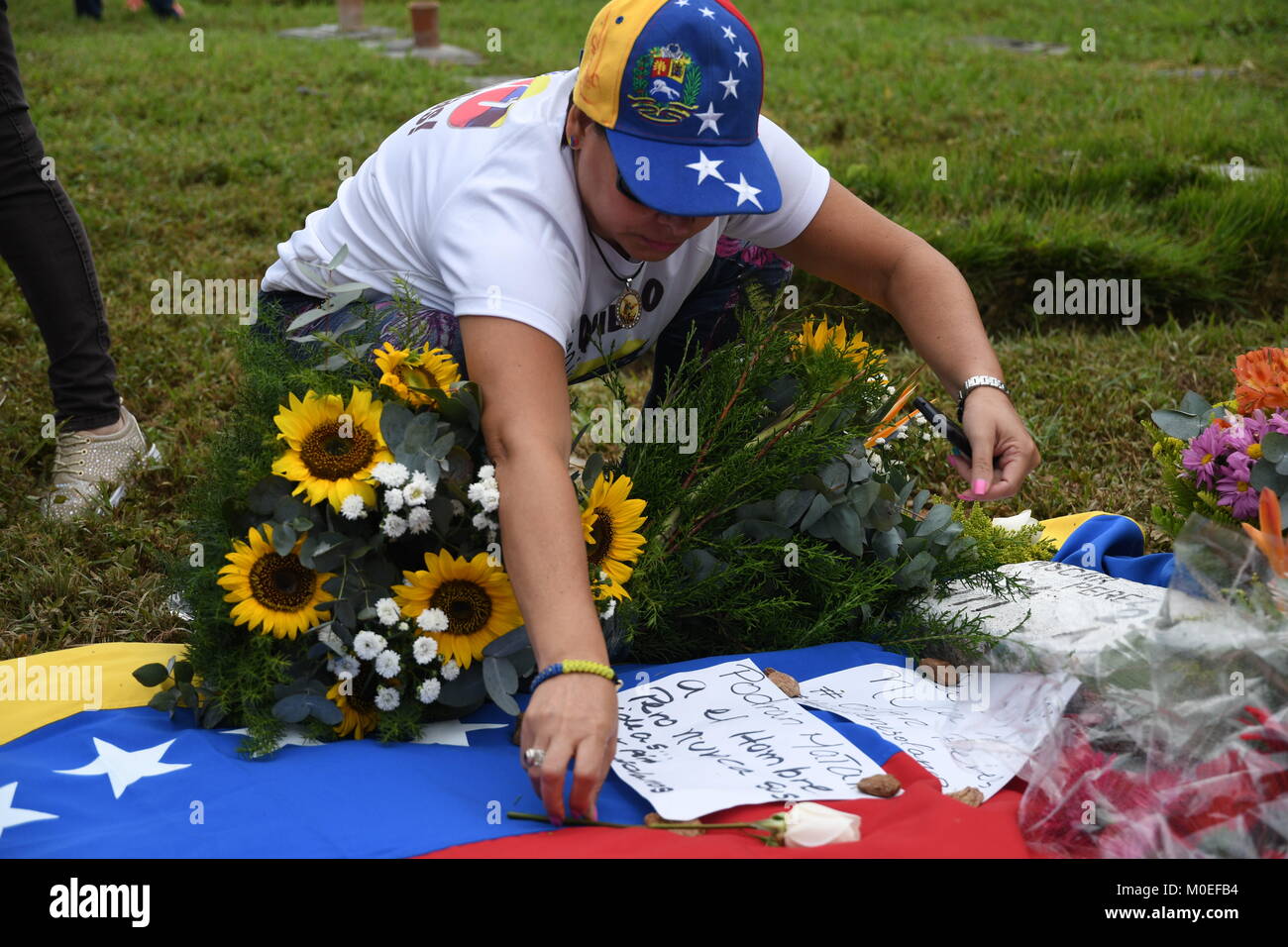 Caracas, Venezuela. Xxi gen, 2018. Un membro della famiglia mettere giù alcune note sulla tomba di Oscar Perez durante il funerale.Il corpo di Oscar Perez, ispettore di polizia scientifica, fu sepolto nel cimitero di orientale. Il funerale era sorvegliato da agenti della Guardia Nazionale e solo la zia potrebbe vedere il corpo e la testimonianza del funerale. Il cimitero è stato chiuso fino a 8:00 am quando la guardia nazionale ha deciso di ritirarsi e consentire l'accesso al pubblico. La società civile e i membri della famiglia pagato rispetto alla tomba dell'ispettore. Credito: Roman Camacho/SOPA/ZUMA filo/Alamy Live News Foto Stock