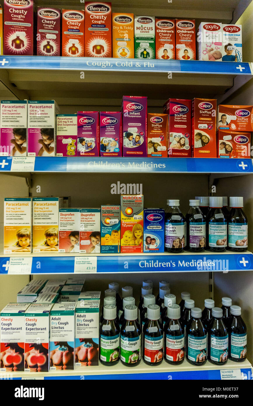 Farmaci contro la tosse e bambini antidolorifici (analgesici) su un ripiano di farmacia in una farmacia inglese. Foto Stock