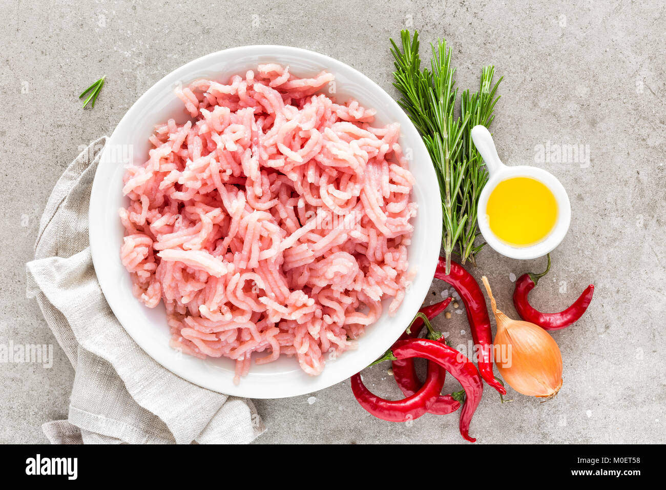 Tritare. La carne di suolo con gli ingredienti per la cottura su sfondo grigio chiaro. Vista superiore Foto Stock