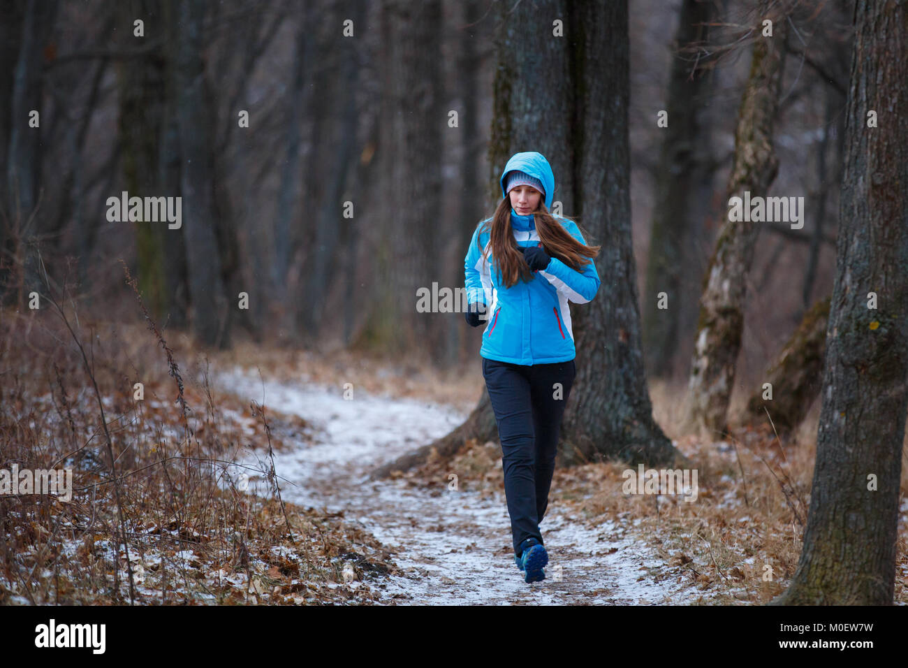 Outdoor attività invernali Concetto di immagine. Giovane donna in esecuzione nel parco in tempo freddo Foto Stock