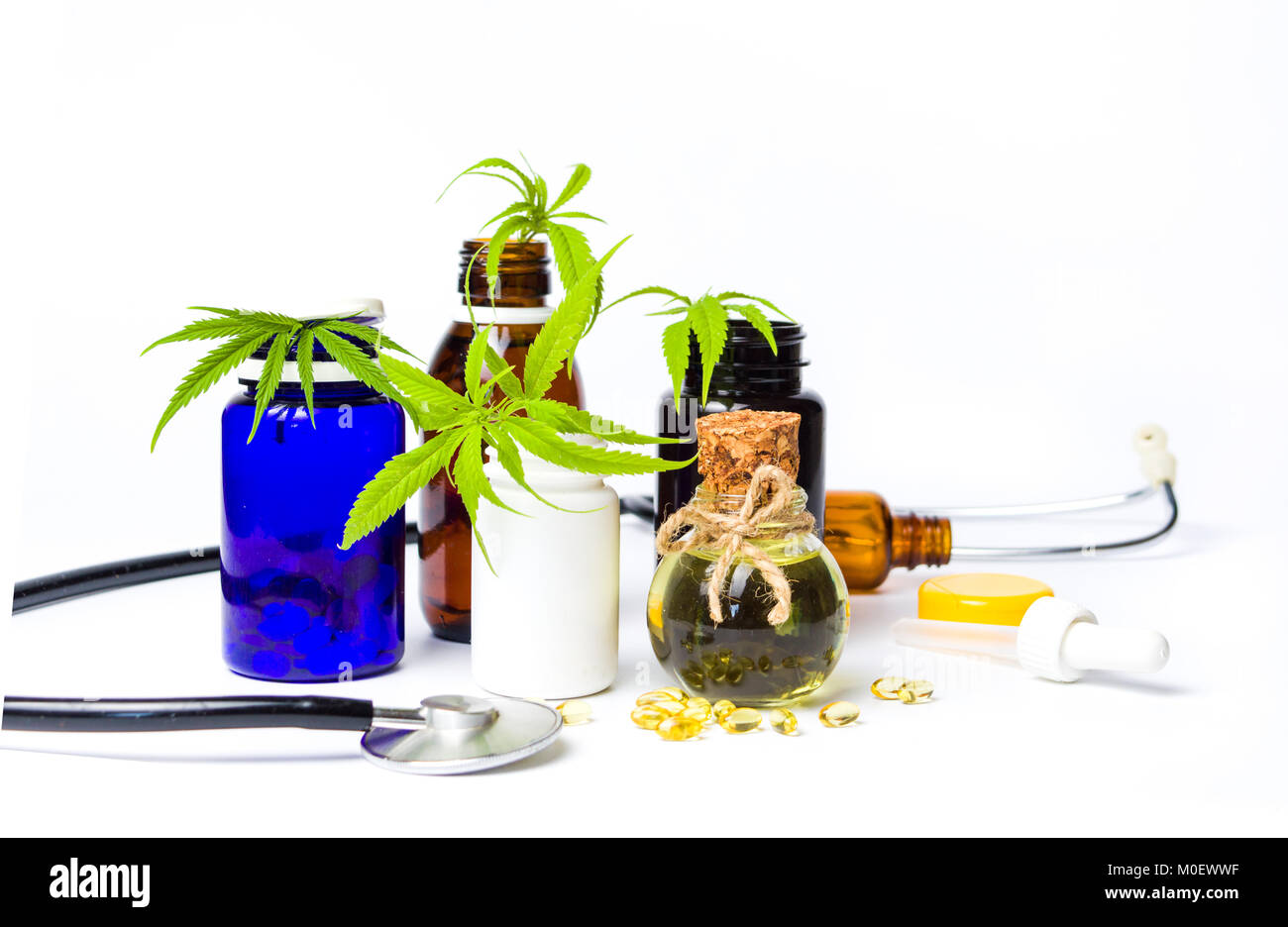La marijuana bottiglie di olio con foglie e uno stetoscopio isolato Foto Stock