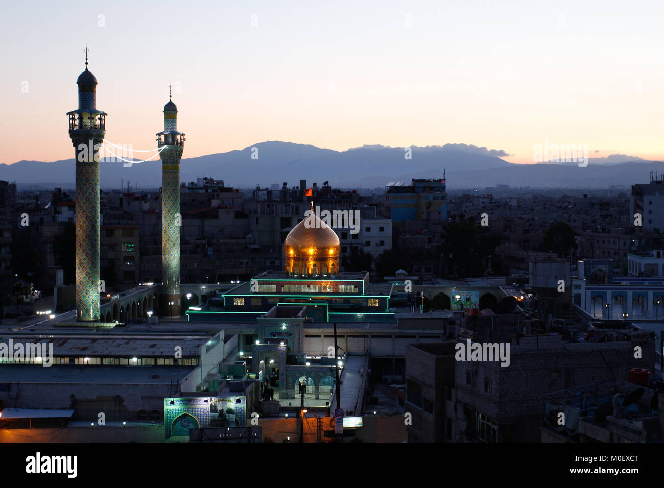 Colpo esterno per Sayeda Zeinab santuario in Damasco Capitale della Siria, che mostra il santuario con una cupola dorata e due minareti e alcuni residenti Foto Stock