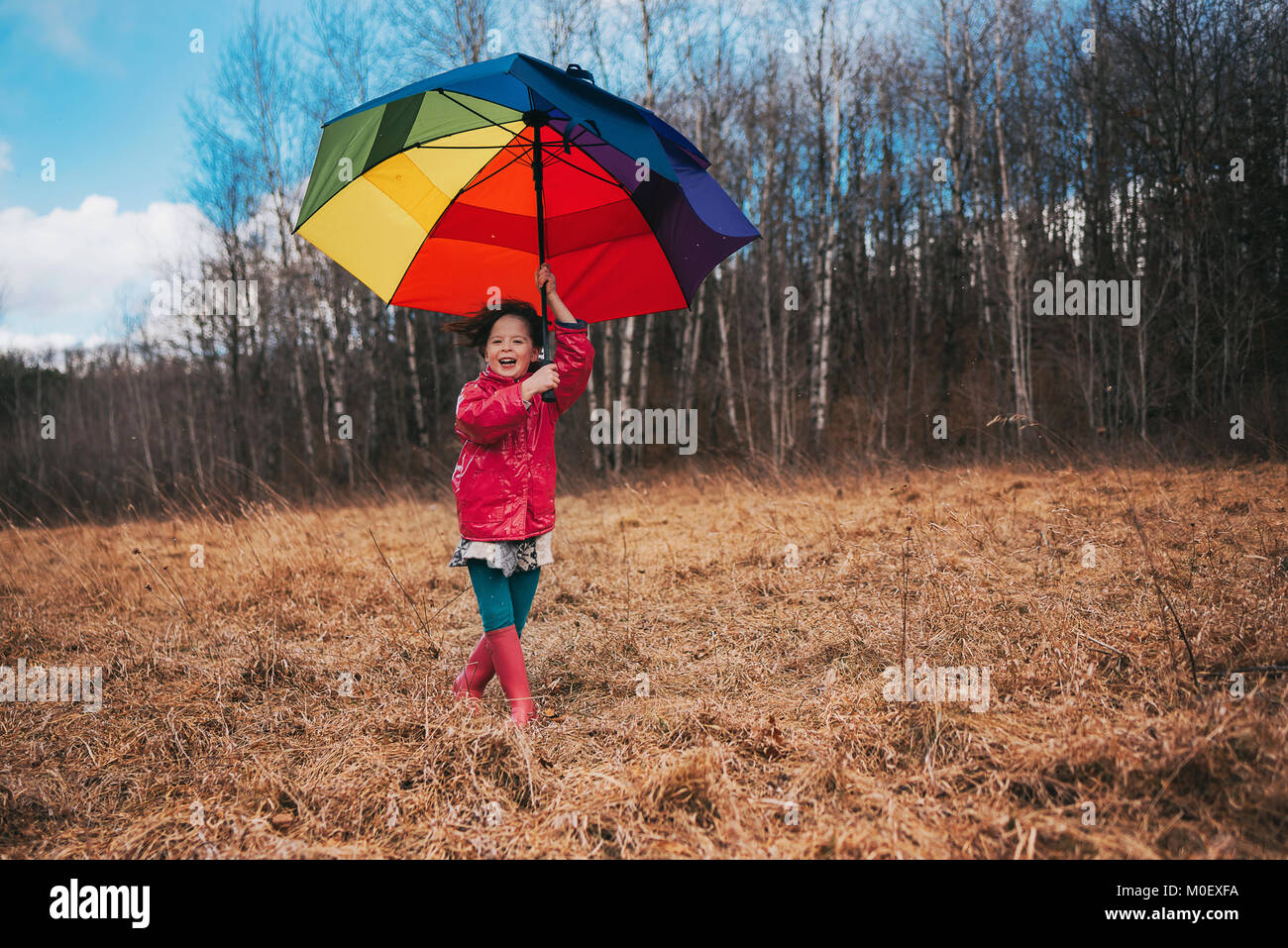Ragazza con un ombrello aperto in una giornata di vento Foto Stock